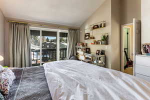 Bedroom featuring lofted ceiling and access to exterior