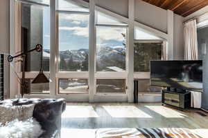 Living room featuring light hardwood / wood-style floors, wooden ceiling, and vaulted ceiling