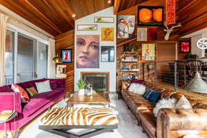 Living room featuring wood ceiling, lofted ceiling, wood walls, and carpet