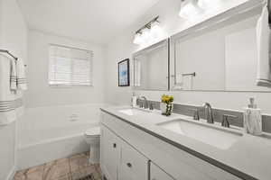 Bathroom with toilet, a bath, and vanity