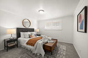 Carpeted bedroom with ornamental molding