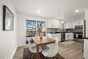 Kitchen featuring tasteful backsplash, appliances with stainless steel finishes, and white cabinetry