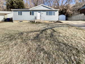 Ranch-style house with a front yard and a shed