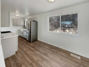 Kitchen with stainless steel appliances, hardwood / wood-style flooring, and gray cabinets