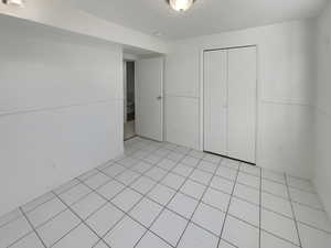 Unfurnished bedroom featuring light tile patterned floors and a closet