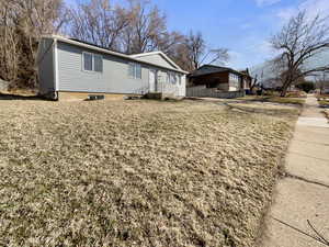 View of side of property featuring a lawn