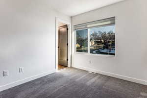 Unfurnished room with a textured ceiling and carpet flooring