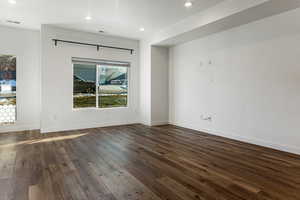 Unfurnished room with dark hardwood / wood-style floors and a textured ceiling