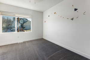 Spare room with a textured ceiling and carpet flooring