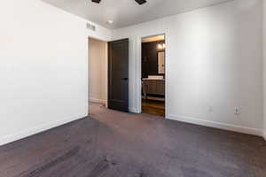 Unfurnished bedroom with dark colored carpet