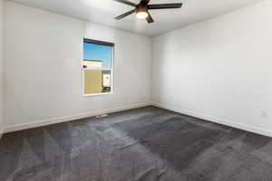 Carpeted spare room featuring ceiling fan and a textured ceiling