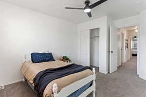 Bedroom with ceiling fan, carpet flooring, and a closet