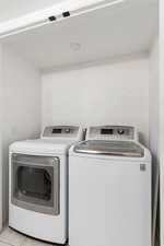 Laundry room featuring washing machine and dryer and light tile patterned floors