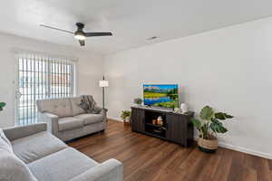 Living room with ceiling fan, dark hardwood / wood-style floors, and a textured ceiling