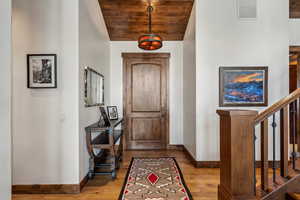 Entryway featuring hardwood / wood-style floors, wood ceiling, and vaulted ceiling