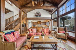 Living room featuring beamed ceiling, wood ceiling, light hardwood / wood-style flooring, and high vaulted ceiling