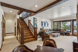 Carpeted living room featuring beam ceiling