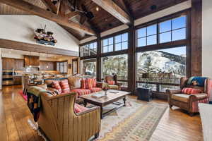 Living room with high vaulted ceiling, a mountain view, light hardwood / wood-style floors, and wooden ceiling