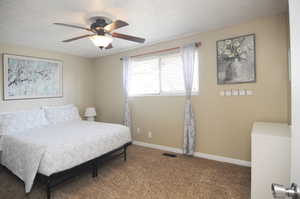 Carpeted bedroom featuring ceiling fan