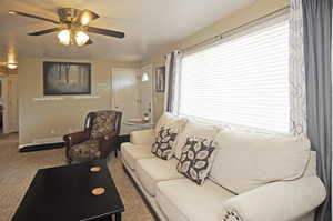 Living room featuring ceiling fan and carpet flooring