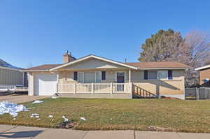 Ranch-style house featuring a garage, a front lawn, and a porch