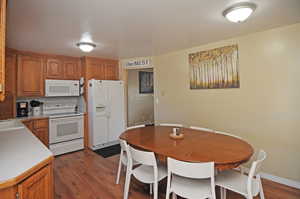 Kitchen with dark hardwood / wood-style floors, sink, and white appliances