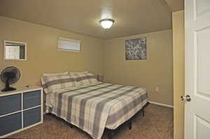 Bedroom with a textured ceiling and dark carpet