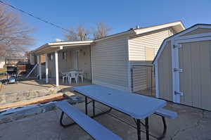 Rear view of house featuring a storage unit and a patio area