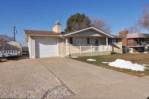 Single story home featuring a front yard, covered porch, and a garage