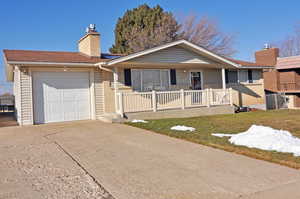 Ranch-style home with a garage, a front yard, and a porch