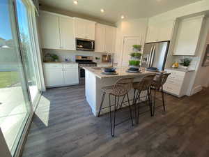 Kitchen with sink, white cabinets, stainless steel appliances, and a kitchen island with sink