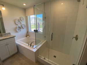 Bathroom with tile patterned floors, vanity, and independent shower and bath