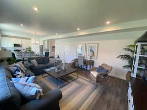 Living room featuring dark wood-type flooring and a chandelier