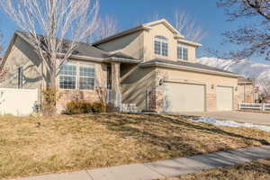 View of property featuring a front yard, a garage, and a mountain view