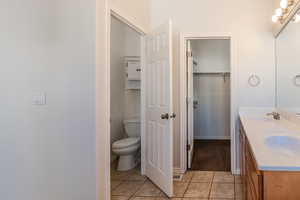 Bathroom featuring toilet, vanity, and tile patterned flooring