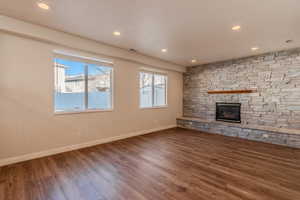 Unfurnished living room with dark hardwood / wood-style flooring and a fireplace