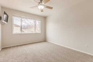 Unfurnished room featuring ceiling fan and carpet flooring