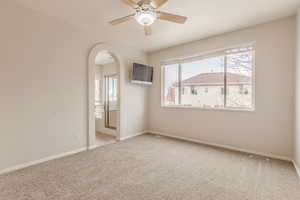 Carpeted empty room featuring ceiling fan