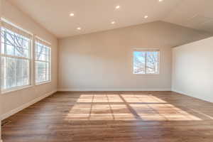 Empty room featuring light wood-type flooring and lofted ceiling