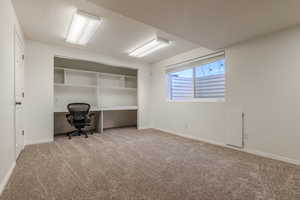 Unfurnished office featuring light colored carpet and a textured ceiling