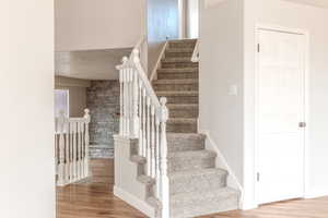 Staircase featuring hardwood / wood-style flooring