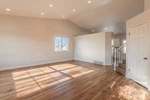 Spare room featuring light hardwood / wood-style flooring and lofted ceiling