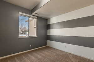 Carpeted spare room with a textured ceiling