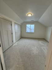 Bonus room with lofted ceiling and a textured ceiling