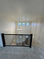 Stairway with a textured ceiling and an inviting chandelier