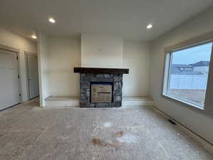 Unfurnished living room featuring a stone fireplace