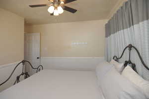 Bedroom featuring ceiling fan and a textured ceiling