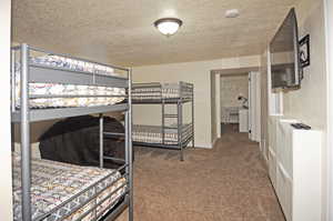 Bedroom featuring a textured ceiling and carpet