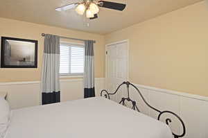 Bedroom featuring ceiling fan and a textured ceiling