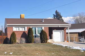 Single story home with a front lawn, a garage, and a mountain view